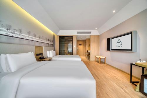 a hotel room with two beds and a tv at Atour Hotel Canal Hangzhou in Hangzhou