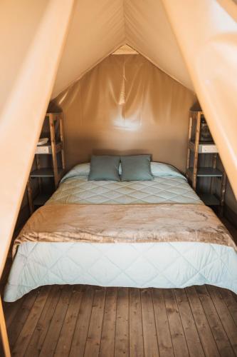 a bed in a tent with two pillows on it at Camping Rodas in Roses