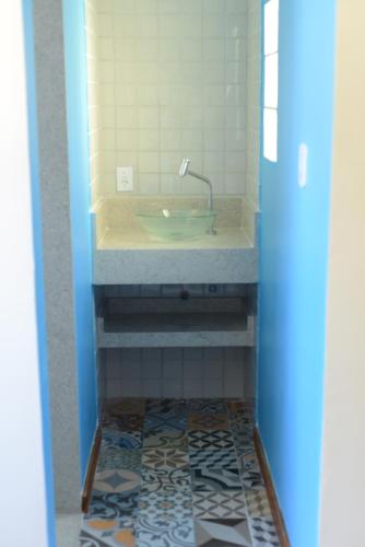 uma casa de banho com lavatório e piso em azulejo em Pousada Paraíso de Itaúna em Saquarema