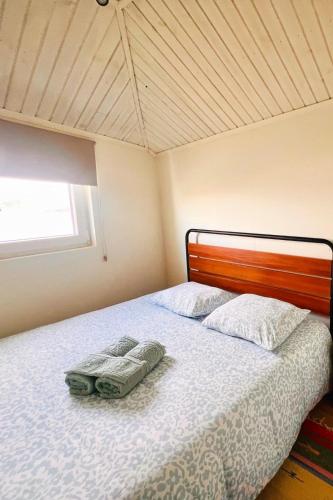 a bedroom with a bed with two pillows and a window at Cozy House with Douro View in Lamego