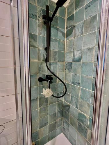 a shower with a hose on a tiled wall at Cozy House with Douro View in Lamego
