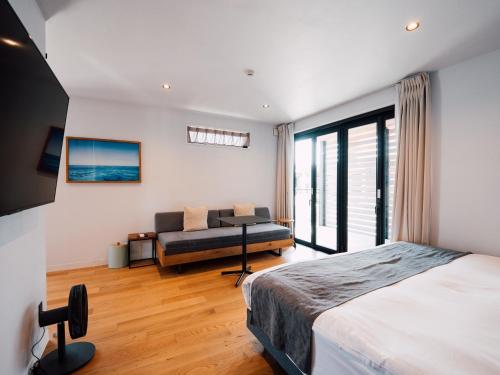 a bedroom with a bed and a couch at ＨＯＴＥＬ ＬＯＣＡＬ ＢＡＳＥ＜宮古島＞ in Miyako-jima