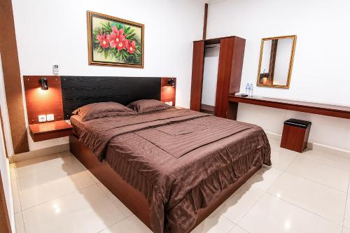 a bedroom with a bed and a picture on the wall at Rays Residence in Jakarta