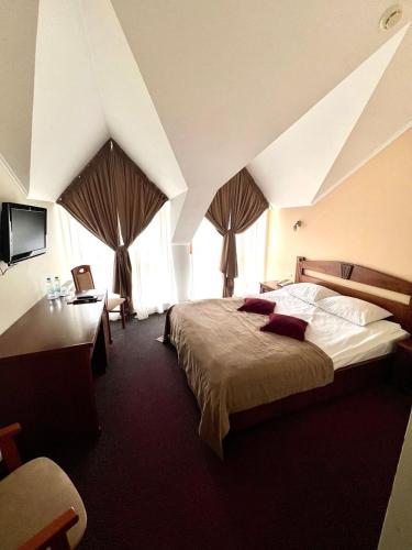 a hotel room with a bed and a desk and window at Копа Баварія - Львів Готель in Pasiky-Zubryts'ki