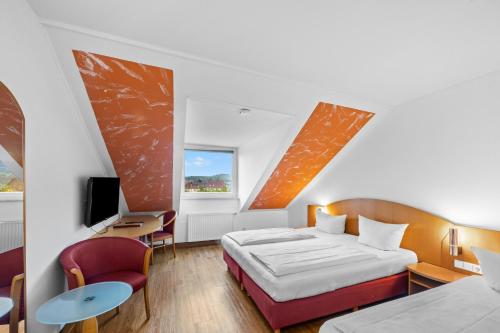 ein Hotelzimmer mit Bett und Schreibtisch in der Unterkunft Hotel SunParc - SHUTTLE zum Europa-Park Rust 4km & Rulantica 2km in Ringsheim