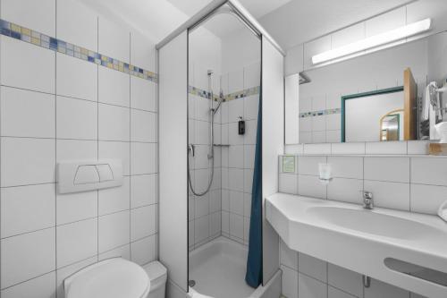 ein Badezimmer mit Dusche, Toilette und Waschbecken in der Unterkunft Hotel SunParc - SHUTTLE zum Europa-Park Rust 4km & Rulantica 2km in Ringsheim