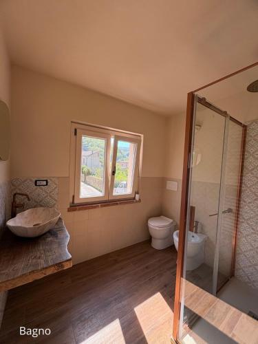 a bathroom with a toilet and a glass shower at Cà del Bosco Appartamento Castagno in Il Romito