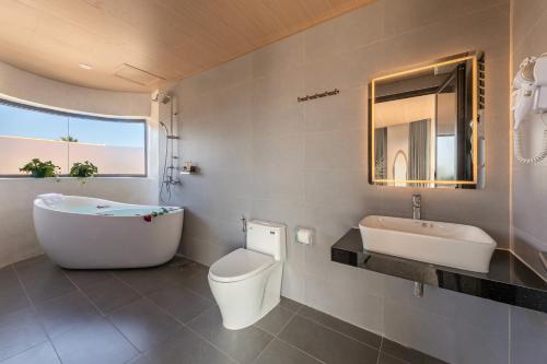 a bathroom with a tub and a toilet and a sink at Ban Mai Village in Phú Hiệp
