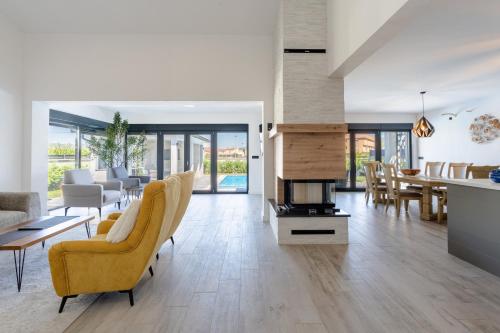 a living room with a fireplace and a dining room at Villa Mirage in Blagaj