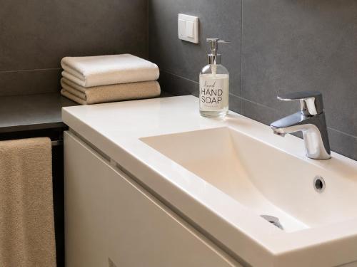 a bathroom sink with a bottle of hand soap on it at nel cuore di Bormio in Bormio