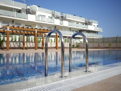 a swimming pool in front of a building at Luxury Apartment Las Terrazas in El Médano