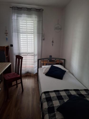 a bedroom with a bed and a chair and a window at Cozy Condo Rovinj in Rovinj
