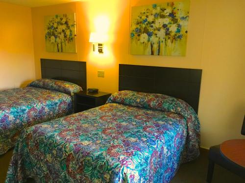 a hotel room with two beds and paintings on the wall at Oak Mar Motel in Oakland