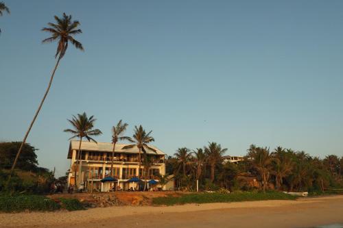 a large house on the beach with palm trees at The Seascape in Matara