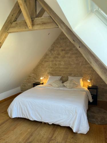 a bedroom with a white bed in the attic at Le Clos d'Hydrequent in Rinxent