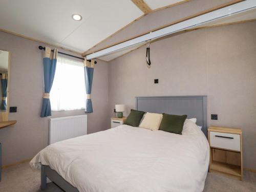 a bedroom with a large white bed and a window at Coastal Escape in Par