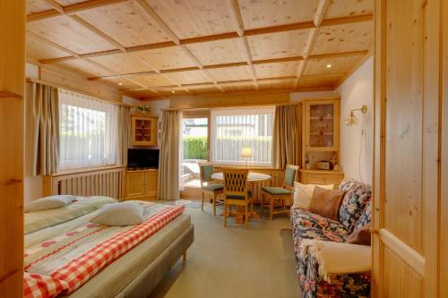 a bedroom with a bed and a dining room at Seefeld ALPIN Apartments in Seefeld in Tirol