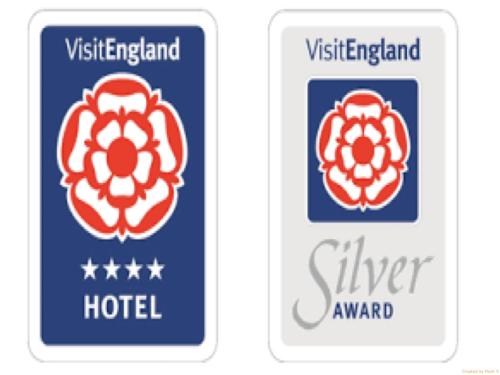 two signs for a hotel with a red flower at The Railway Apartments in Haydon Bridge
