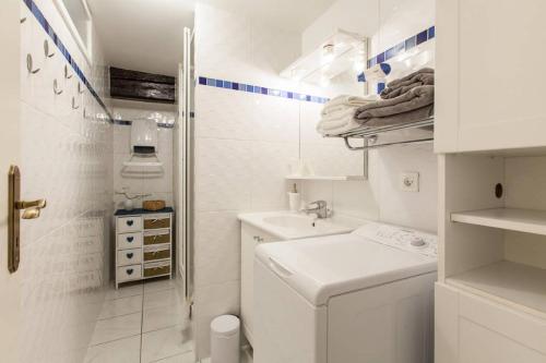 Un baño blanco con inodoro y lavabo. en Le Cocon Petite France, en Estrasburgo