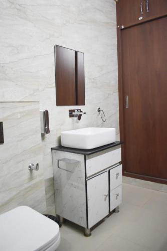 a bathroom with a sink and a toilet at Pinewood Manor in Dagshai