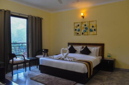 a hotel room with a bed and a balcony at Pinewood Manor in Dagshai
