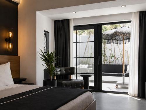 a bedroom with a bed and a sliding glass door at The Local House Alaçatı in Alaçatı