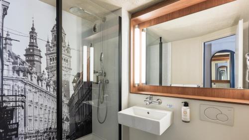 a bathroom with a sink and a shower at Campanile NATURE - Lille Wasquehal in Wasquehal