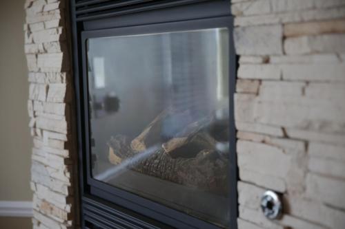 a fireplace with logs inside of it at Weathervane Inn in Montague