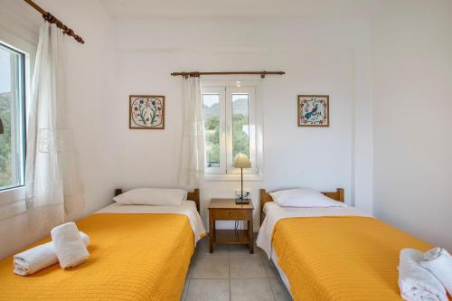 two beds in a room with yellow sheets at Libyan Sea Sunset in Kerames