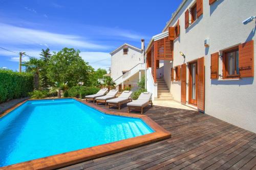 a swimming pool with lounge chairs next to a house at Villa San Vista with pool in Sveti Vid-Miholjice