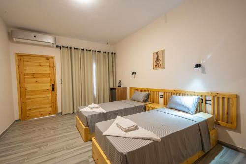 a bedroom with two beds and a door at Amun Dahab Hotel in Dahab