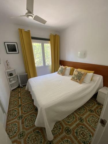 a bedroom with a large white bed and a window at VILLA CATALUNYA in Cambrils