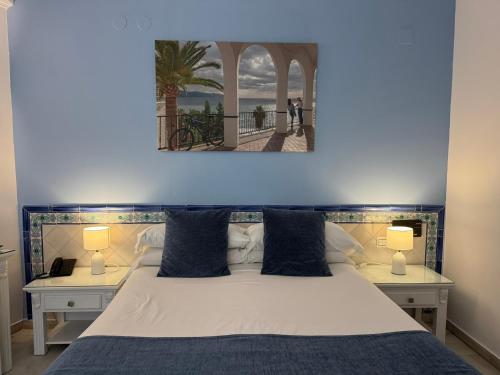 a bedroom with a large bed with two night stands at Hotel Plaza Cavana in Nerja