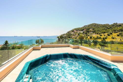 a hot tub on a balcony with a view of the ocean at Vamavi Maison - Villa with Private Pool, Salamina in Salamina