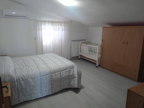 a bedroom with a bed and a crib at La casa di Rosy in Alba Adriatica