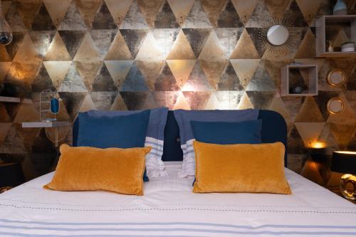 a bedroom with a bed with blue and orange pillows at La Chambre Loft in Hennebont