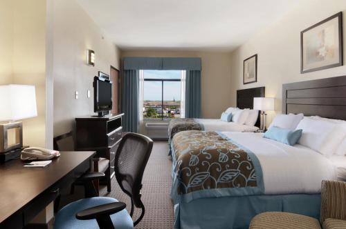 a hotel room with two beds and a desk at Wingate by Wyndham New Braunfels in New Braunfels
