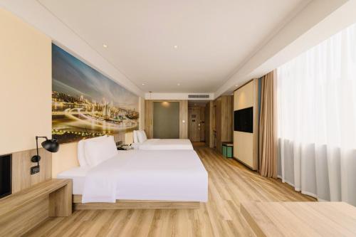 a hotel room with a white bed and a painting at Atour Hotel Chongqing Jiefangbei in Chongqing