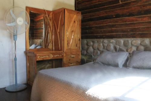 1 dormitorio con 1 cama con ventilador y vestidor en Cabañas y Toboganes Rancho la Ñata, en Mina Clavero