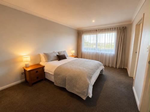 a bedroom with a large bed and a window at Parkside in Bethlehem in Tauranga