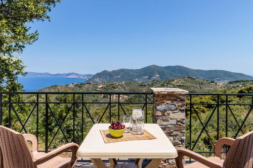 a table with a bowl of fruit on top of a balcony at Kastanies Ananias Skopelos in Skopelos Town