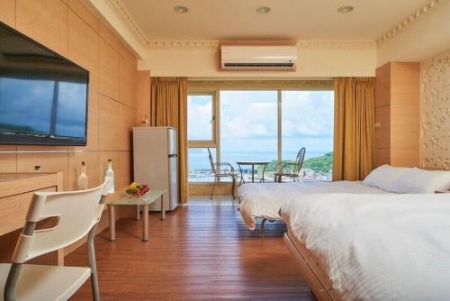 a bedroom with a large bed and a large window at FJ House ABC in Keelung