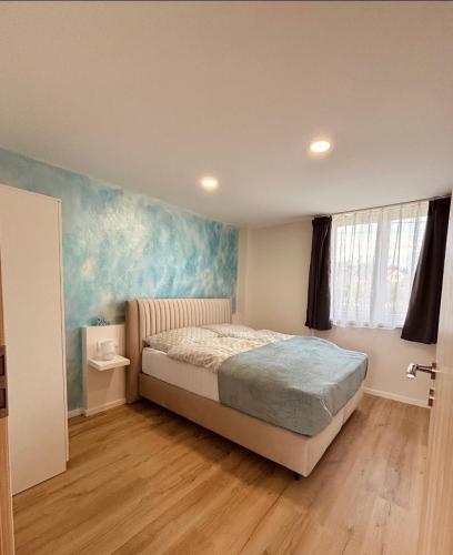 a bedroom with a bed and a painting on the wall at Theodora Apartman in Zánka