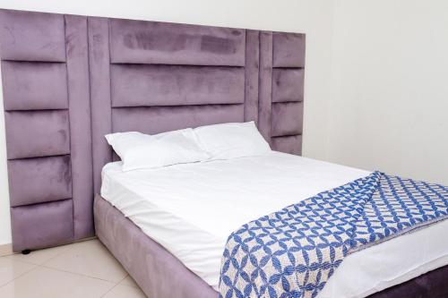 a bed with a purple headboard in a room at RiverfrontOasis - Huge Backyard, Pool, Grand Piano in Sandton