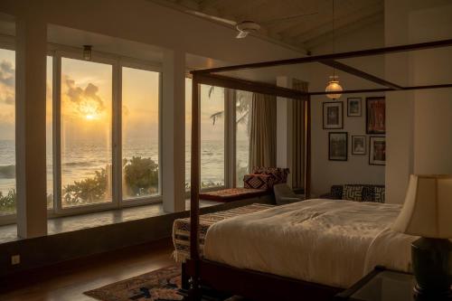 a bedroom with a bed with a view of the ocean at Villa Sayura by TONIK, Boossa - Beachfront in Busse