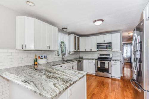 a kitchen with white cabinets and a marble counter top at Corn Hill Ranch in Falmouth