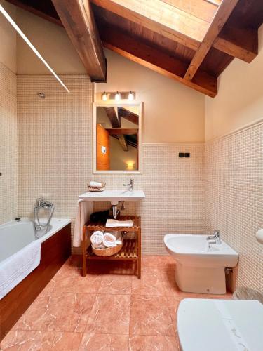 a bathroom with a tub and a toilet and a sink at Hotel Rural El Fundil in El Pino