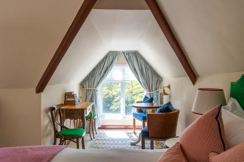 a bedroom with a bed and a desk and a window at The Canford in Poole