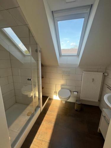 a bathroom with a shower and a toilet and a window at Kiebitz Schmuckstück in Walibo in Lippstadt