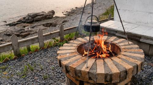 a fire pit with a pot hanging over it at Namhae Pumda Pool villa Pension in Namhae